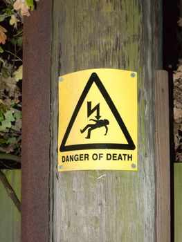 yellow danger of death safety sign outside pole electricity shock; essex; england; uk