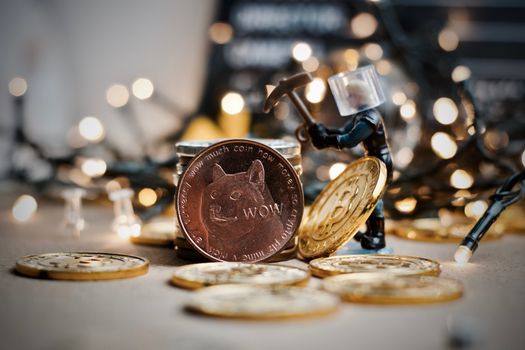Digital currency physical metal brass dogecoin coin. Christmas lights scene.