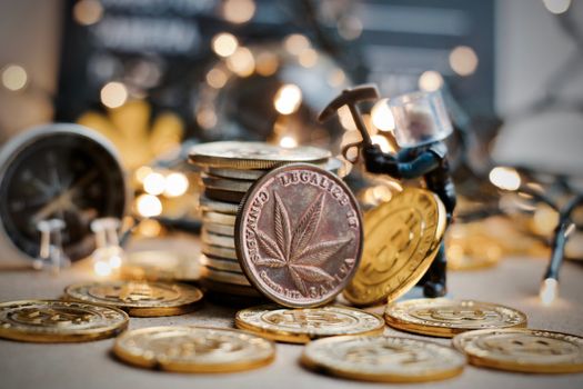 Physical brass marijuana coin with cannabis leaf on the front. Marijuana mining concept.
