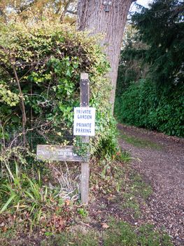 private garden no parking sign on wooden post outside country; essex; england; uk