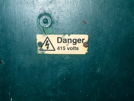 bunch of safety signs water green box yellow triangle; essex; england; uk; danger 415 volts