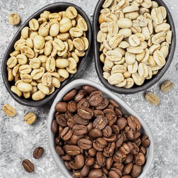 Trendy plates with white, green and brown coffee bean on gray concrete background. Top view or flat lay. Image with natural colors. Square