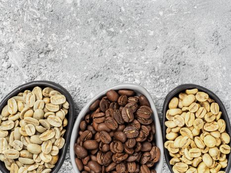 Trendy plates with white, green and brown coffee bean on gray concrete background. Top view or flat lay. Copy space. Image with natural colors.