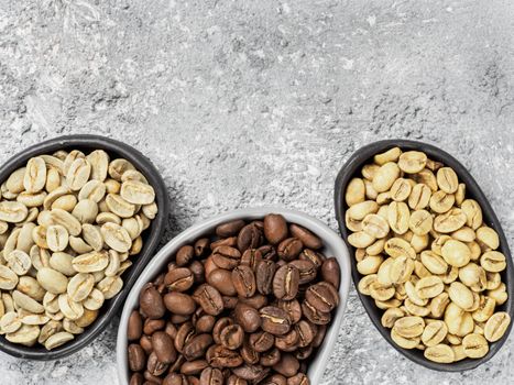 Trendy plates with white, green and brown coffee bean on gray concrete background. Top view or flat lay. Copy space. Image with natural colors.