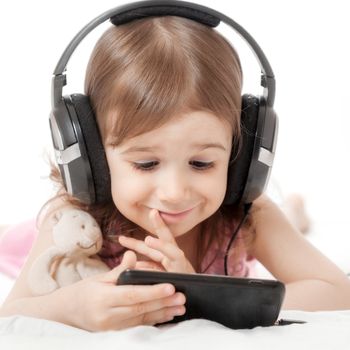 the little girl listens to music in earphones