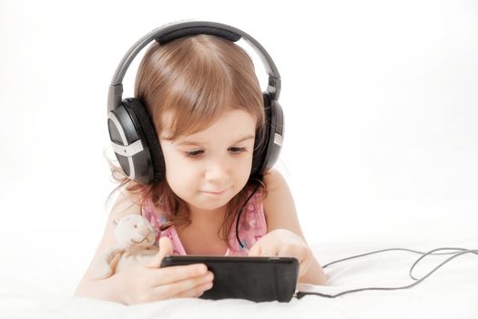 the little girl listens to music in earphones