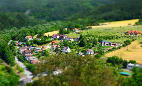 Beautiful village with houses in valley shot with tilt shift effect.