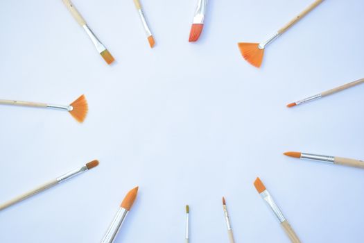 artists paint brushes arranged in a circle giving space for centre content