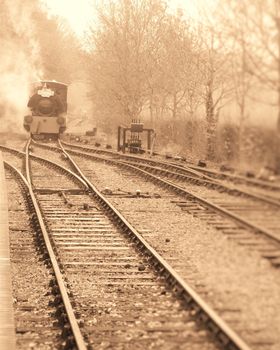 steam engine approaching station along tracks