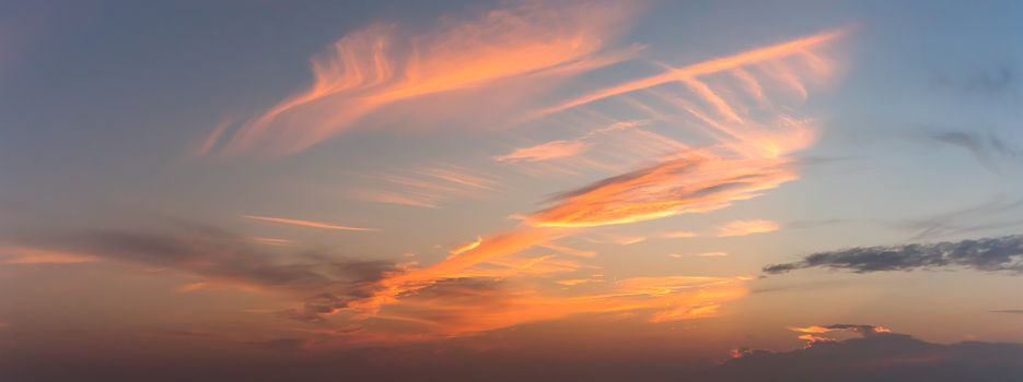 Panoramic orenge fluffy clouds in the twighligth sky