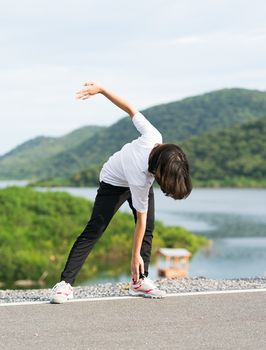 Fitness and lifestyle concept - Young asian woman short hair doing exercising outdoor and warm up preparing for jogging