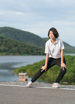 Fitness and lifestyle concept - Young asian woman short hair doing exercising outdoor