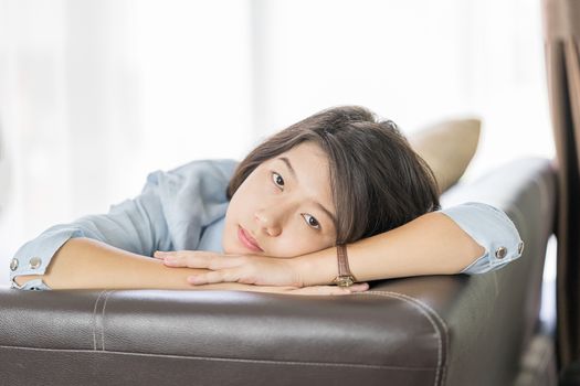 Close up beautiful young asian woman short hair relaxation by side the window in living room at home