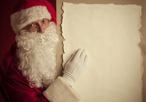 Santa Claus holding vintage paper billboard with copy space for text