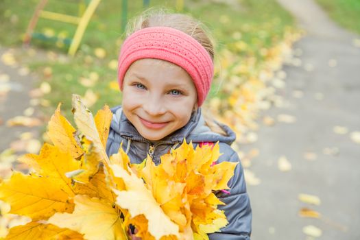 Pretty girl with yellow leaves smiling