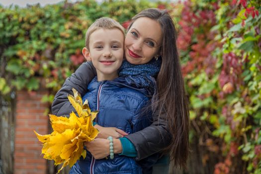 Mother and son hugging among autumn outdoor