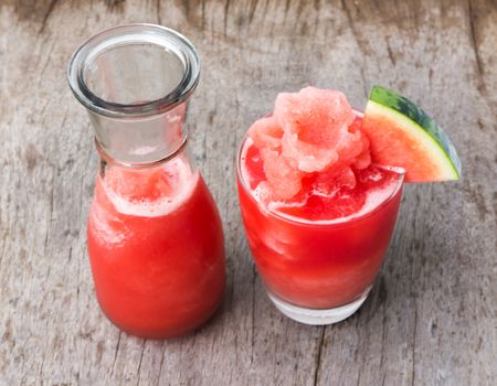 Fresh watermelon smoothie in glass and bottle on wood table, Fruit drink for healthy concept