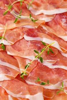 close up of air dried ham slices with thyme - full frame