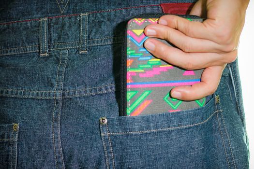 A man taking out his wallet from his jean's back pocket.