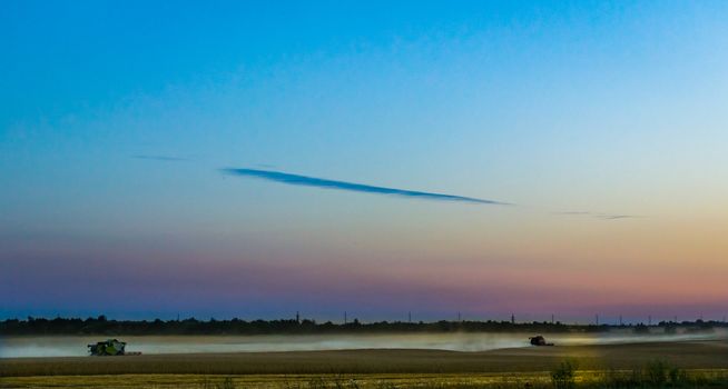 machine harvest wheat field, night moon mountains