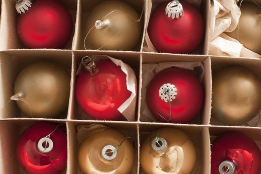 Full frame view of boxed festive red and gold Christmas baubles for decorating a seasonal holiday celebration party, overhead close up view
