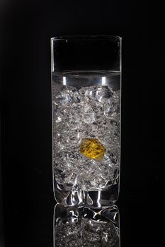 Crystals of ice in a glass with water on a glass background