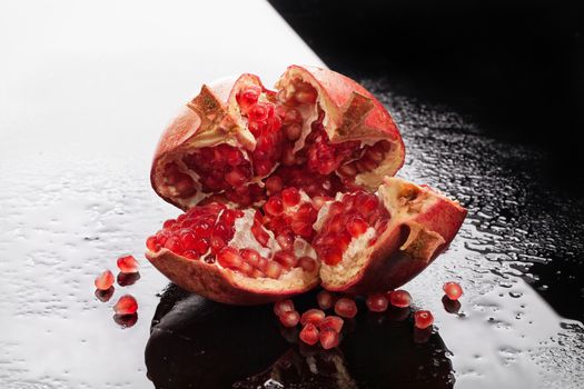 Pomegranate on a glass background with drops of water