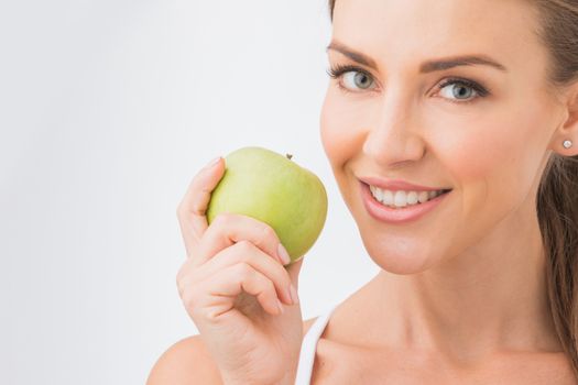Beautiful young nude woman with green apple close up on white background