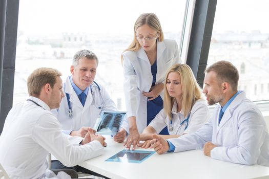 Group of doctors look and discuss x-ray in a clinic or hospital