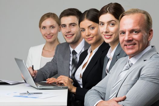 Business people sitting in a row and working with documents and laptop