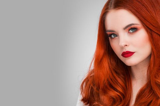 Gorgeous redhead girl with wavy hair beauty studio portrait