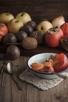 Persimmon fruit on rustic table in vintage style.