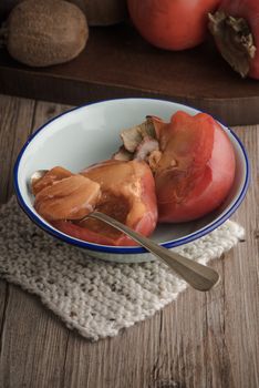 Persimmon fruit on rustic table in vintage style.