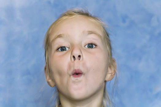 Cute fun girl with blond hair on blue background