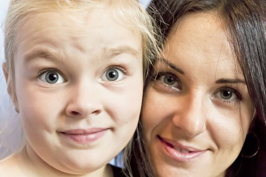 Portrait of cute blond daughter with brunette mother