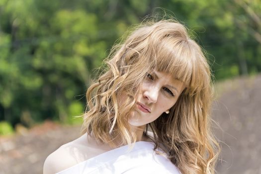 Horizontal portrait of young woman with blond hair on wood background