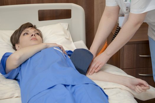 Young female patient in a modern hospital being checked for high blood pressure levels.