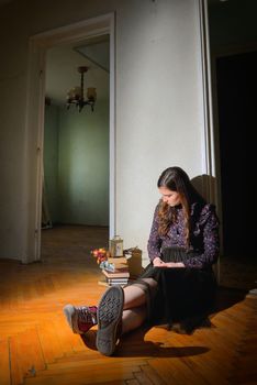 Young girl in black vintage dress in empty house