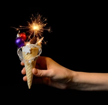 Ice cream cone and christmas decoration on black background