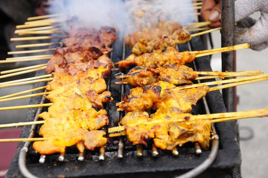 Chicken is grilled on a hot charcoal stove, Thai food.