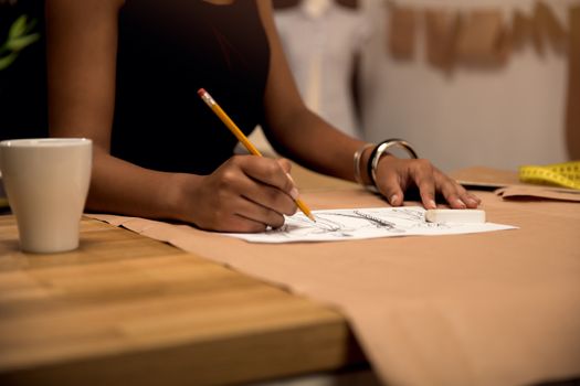 Portrait of a young fashion designer working on her atelier