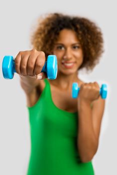 Beautiful African American woman lifting weights 