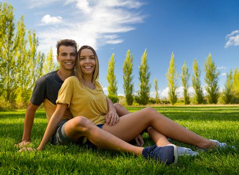 Young couple sitting on the grass and relaxing