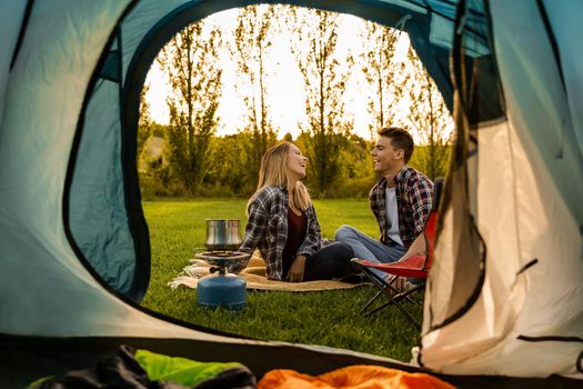 Shot of a happy couple camping on the nature and cooking