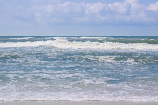 Sea coastal waves rolling on empty sandy beach, stormy cloudy sunrise skyview