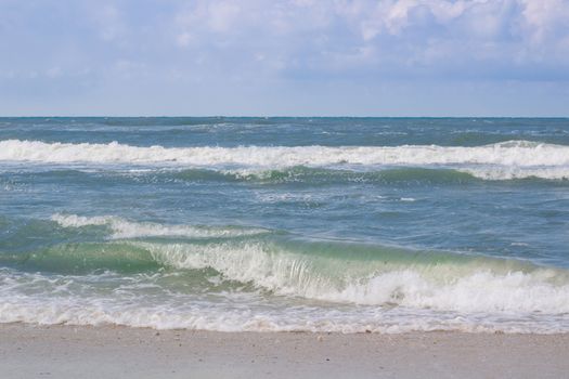 Sea coastal waves rolling on empty sandy beach, stormy cloudy sunrise skyview