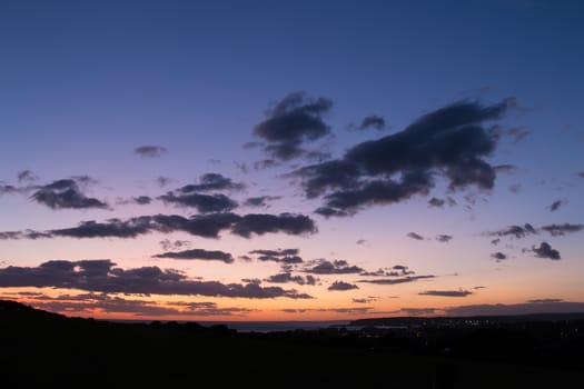 Evening sky just after sunset, with clouds and distant lights from Seaford and Newhaven.