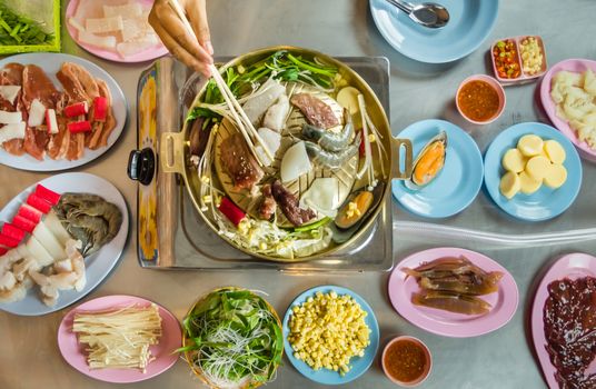 Asian BBQ-Style. Grill sliced pork and seafood on hot pan with vegetable