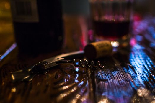 a corkscrew on a wooden table color glow bottle stopper wine