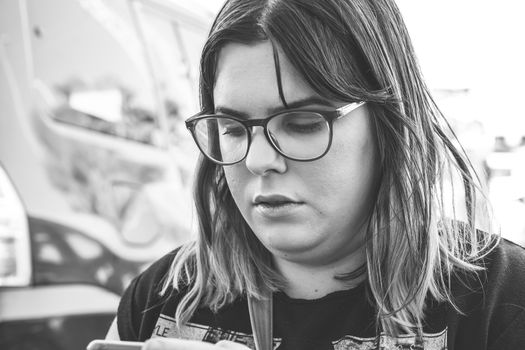 Woman using smartphone on the street. Close up black white image.